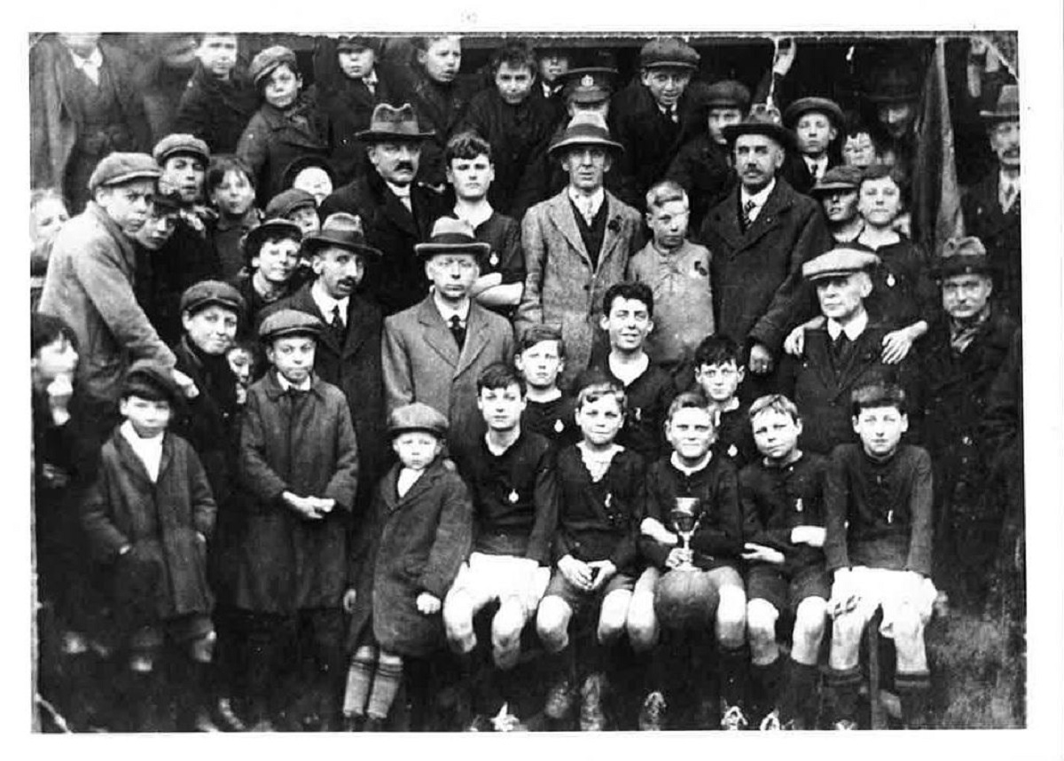 Match of the day - this intriguing picture shows people, presumably parents, gathering round a team of young footballers. The boys were celebrating after winning a cup